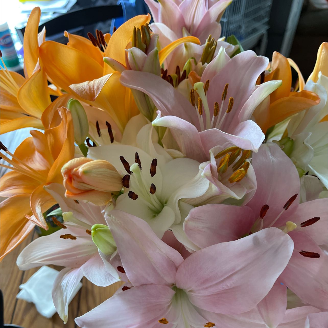 A bouquet of healthy and vibrant lilies in various colors including white, pink, and orange.
