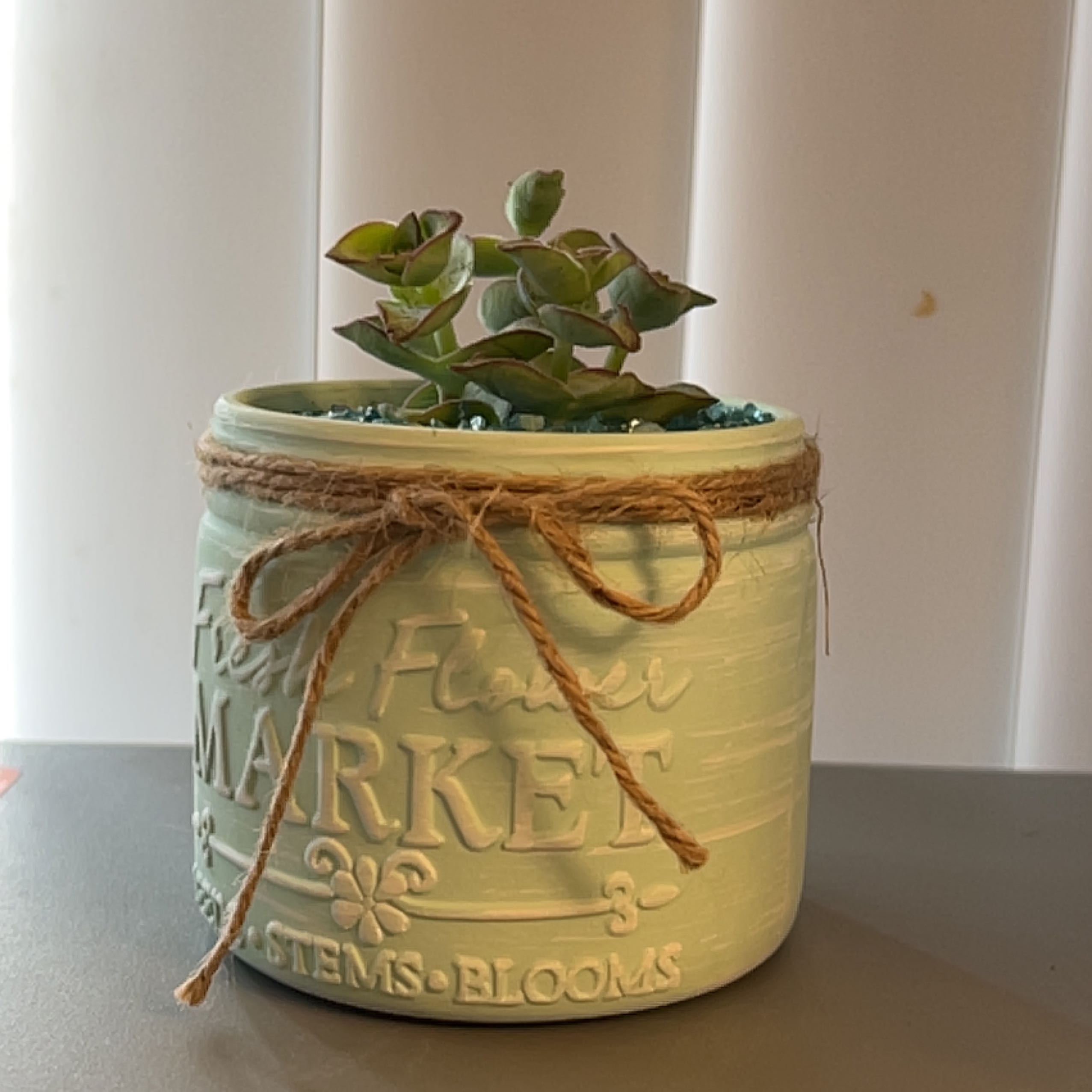 Healthy Crassula perforata succulent in a decorative yellow ceramic pot with 'Farmer's Market' engraved on the side.